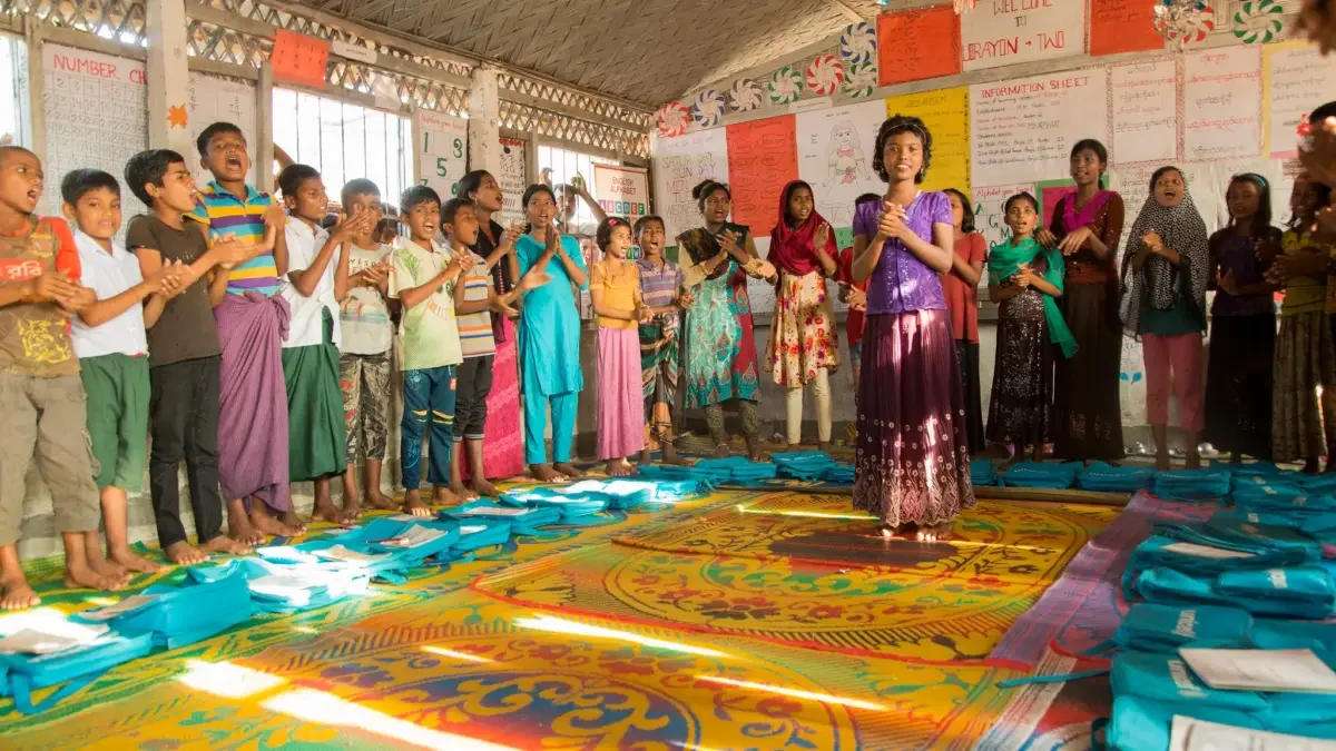 Inside a Bangladesh refugee camp a classroom of Rohingya children sing English songs at a UNICEF learning centre, funded by UK aid. Photo credit: Anna Dubuis/DFID via Flickr.